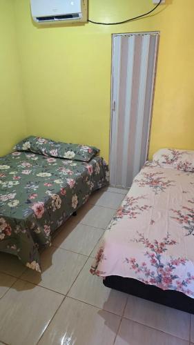 a room with two beds and a door in it at Apto B com cozinha em Macapa Terra Nova in Macapá