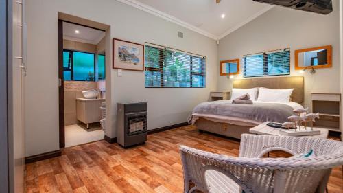 Un dormitorio con una cama y una chimenea. en Waterside Holiday House, en Wilderness