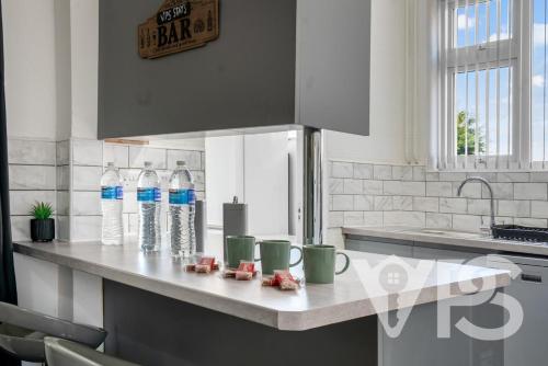 レスターにあるFamily&GroupRetreat GamesRoomのキッチン(カウンターにボトル入り飲料水2本付)