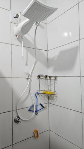 a shower in a white tiled bathroom at Casa JB in Chapada dos Guimarães