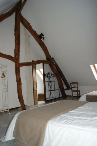 - une chambre avec un lit et des poutres apparentes dans l'établissement Gîte Typique Normand, à Bretteville-du-Grand Caux