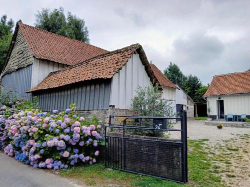 a building with a gate in front of a bunch of flowers at Les Oliviers in Chériennes