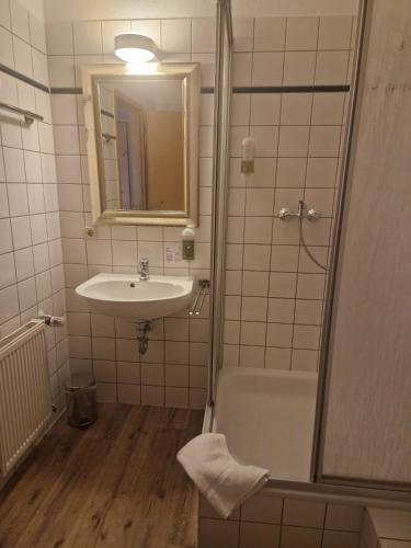 a bathroom with a sink and a bath tub and a mirror at Hildebrandts Landhotel in Klettbach