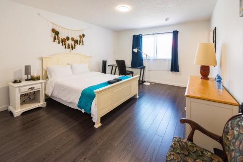 a bedroom with a bed and a desk and a chair at Bright & Spacious House Near UBC in Vancouver