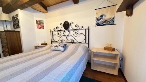 a bedroom with a large bed and a table at Mansarda Chiara - locazione turistica in Gosaldo