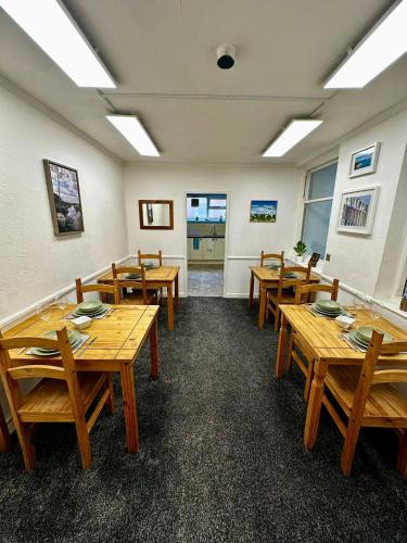 a dining room with wooden tables and chairs at Rembrandt Guest House in Great Yarmouth