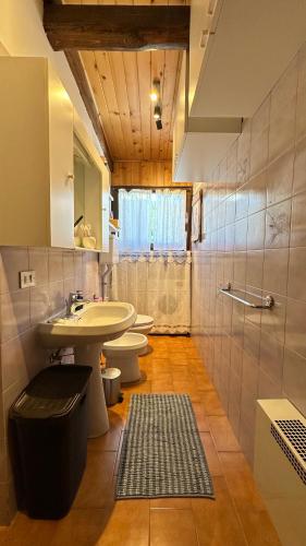 a bathroom with two toilets and a sink and a mirror at Mansarda Chiara - locazione turistica in Gosaldo