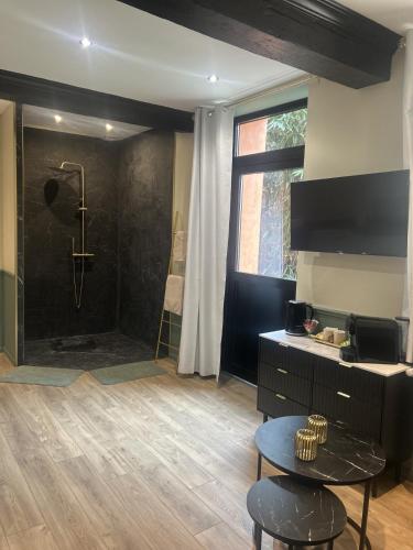 a large bathroom with a shower with a table and a table at La Suite Fernand Bar in Béthune
