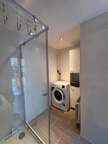 a bathroom with a washing machine and a washer at Mooi chalet op de Veluwe! in Lunteren