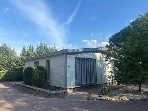 a small house sitting on top of a driveway at Mooi chalet op de Veluwe! in Lunteren