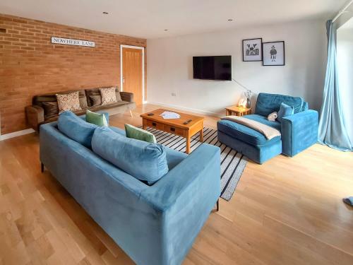 a living room with two blue couches and a table at No 2 Badger Sett-Uk44307 in Lenwade