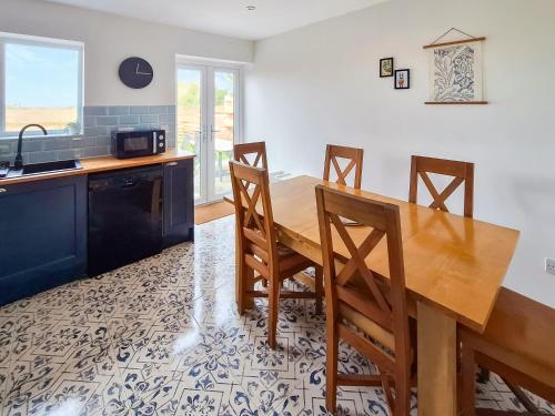 a kitchen with a wooden dining room table and chairs at No 2 Badger Sett-Uk44307 in Lenwade