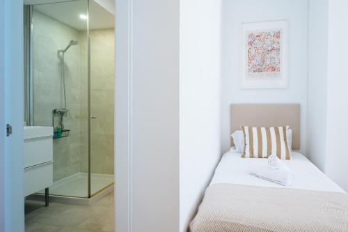 Un dormitorio con una cama y una ducha de cristal. en Al Sur Home Marqués, en Sevilla