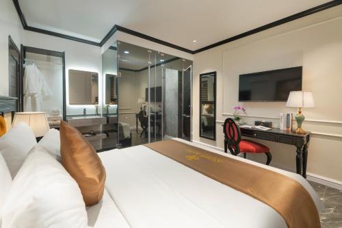 a bedroom with a large white bed and a desk at Golden Boutique Hotel in Hanoi