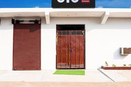 a white building with a gate and a door at SPOT ON Hotel Lakshya Ghatampur in Kānpur
