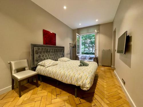 une chambre avec un lit, une chaise et une fenêtre dans l'établissement Appartement Tour Eiffel Montaigne, à Paris