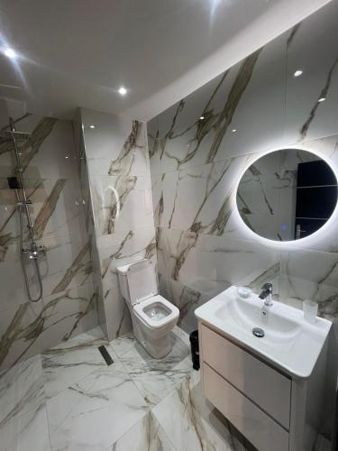a bathroom with a white toilet and a sink at Helgis Center in Himare