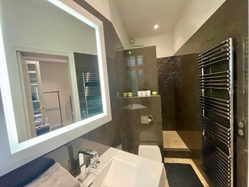 une salle de bain avec un lavabo et un miroir dans l'établissement Appartement Tour Eiffel Montaigne, à Paris