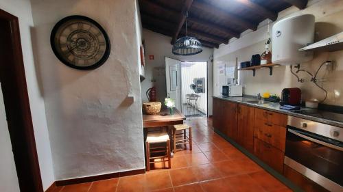 a kitchen with a clock on the wall at Casa do Lêntejo - Casas de Taipa in São Pedro do Corval