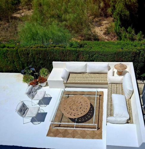 a living room with a white couch and chairs at Casa Junto a la Playa in El Rompido