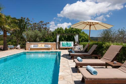 a swimming pool with lounge chairs and an umbrella at Villa Can Coves in Sant Miquel de Balansat