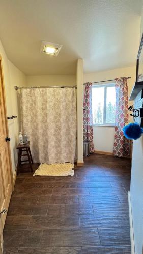 a living room with a window and a wooden floor at Majestic View Roundhouse - Relax Room in Wasilla