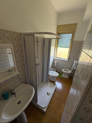 a bathroom with a shower and a sink and a toilet at Hotel La Quiete in Sinagra