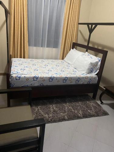 a small bed in a room with a bed frame at Serenity Garden House in Nkunjila