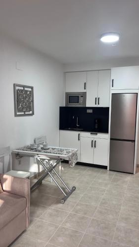 a kitchen with a table and a stainless steel refrigerator at Brisa Marina Apartamento con vistas al mar in Mazagón