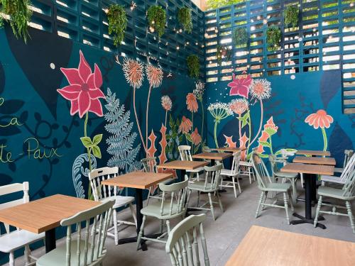 a restaurant with tables and chairs and a wall with flowers at La Sainte Paix in Quebec City