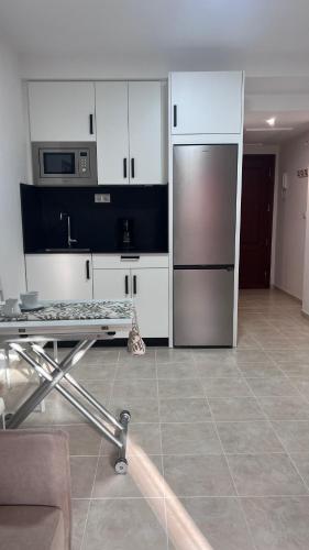 a kitchen with a stainless steel refrigerator and white cabinets at Brisa Marina Apartamento con vistas al mar in Mazagón