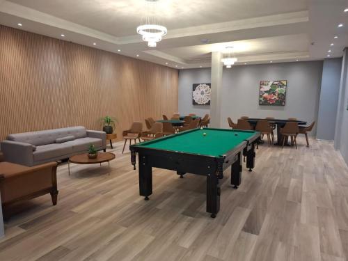 a room with a pool table and tables and chairs at Resort Gran Paradiso Campos do Jordão in Campos do Jordão