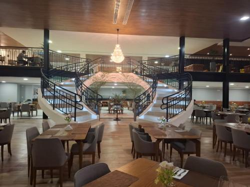 a restaurant with tables and stairs in the middle at Resort Gran Paradiso Campos do Jordão in Campos do Jordão