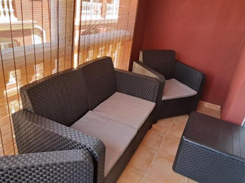 two empty chairs in a waiting room with a couch at Brisa Marina Apartamento con vistas al mar in Mazagón