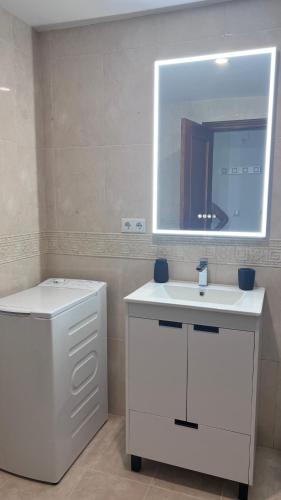 a bathroom with a white sink and a mirror at Brisa Marina Apartamento con vistas al mar in Mazagón