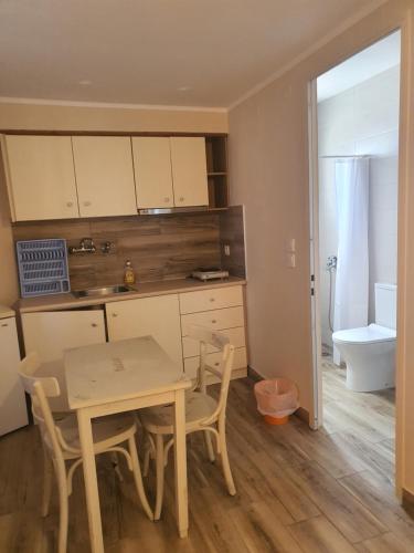 a kitchen with a table and a sink and a toilet at Magda in Loutra Edipsou