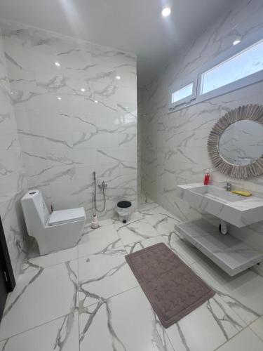une salle de bain blanche avec un lavabo et des toilettes dans l'établissement AL MIDIAF STYLISH VILLA &Garage, à Mostaganem