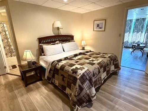 ein Schlafzimmer mit einem Bett und einem Tisch mit Lampen in der Unterkunft Skaneateles Inn on 20 in Auburn