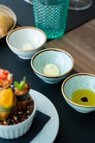 a group of bowls of food on a table at Porto Covo Praia Hotel & SPA in Porto Covo