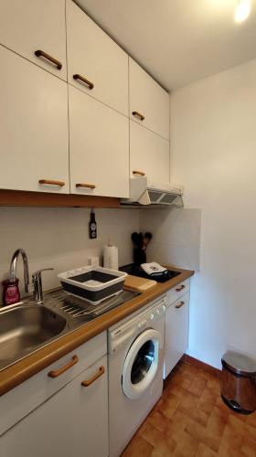 a kitchen with a sink and a washing machine at Sullensa # Parking - Proche Centre - Vue Montagne in Thônes