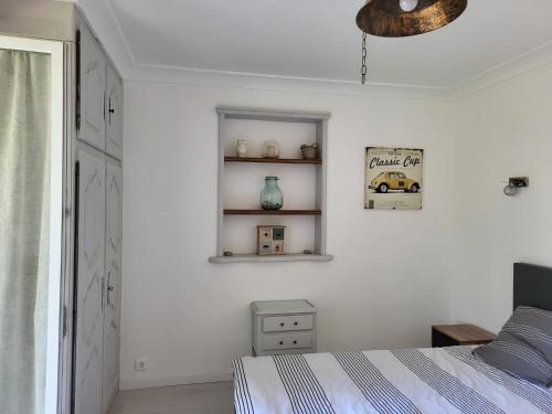 une chambre blanche avec un lit et une fenêtre dans l'établissement Maison au calme absolue, à Saint-Cézaire-sur-Siagne