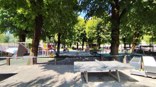 a park with a playground with a bench and trees at Sullensa # Parking - Proche Centre - Vue Montagne in Thônes