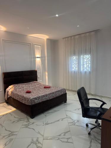 une chambre avec un lit, un bureau et une chaise dans l'établissement AL MIDIAF STYLISH VILLA &Garage, à Mostaganem