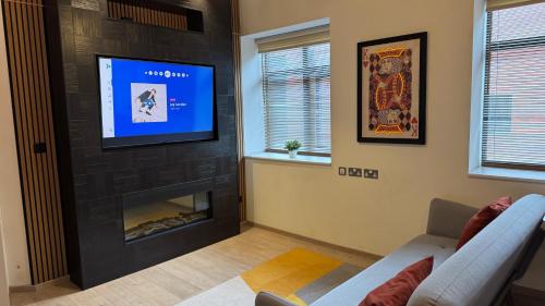 a living room with a fireplace and a flat screen tv at Ultra-Central Loft Penthouse Sky Sports & Movies in Leeds