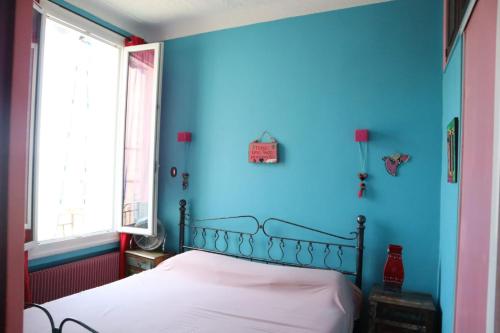 une chambre bleue avec un lit dans une pièce dans l'établissement Belle vue mer, à Cannes
