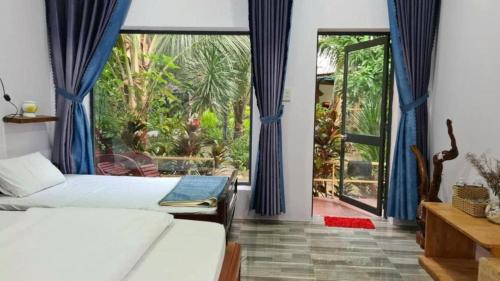 a bedroom with two beds and a large window at Blue coconut villa in Kon Rung (1)