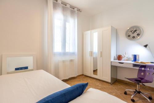 ポルト・トッレスにあるMaison Apartments Porto Torres Centerのベッドルーム1室(ベッド1台、デスク、時計付)