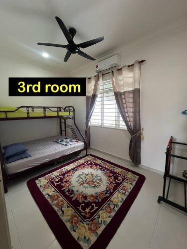 a room with two bunk beds and a rug on the floor at Almai Homestay Batu 4 in Port Dickson