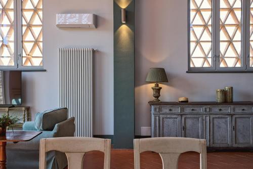 a living room with a table and chairs and a radiator at Castello Vicchiomaggio in Greve in Chianti