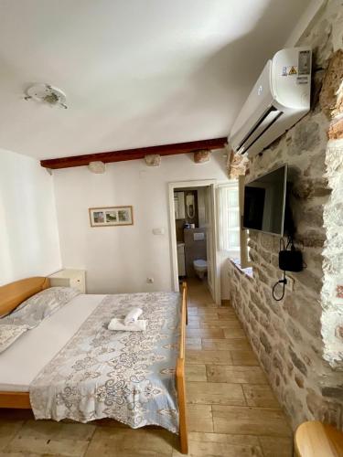 a bedroom with a bed and a stone wall at Apartments Đukić in Kotor